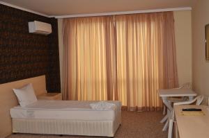 普里莫尔斯科La Piazza Primorsko Rooms & Apartments的一间卧室配有一张床、一张书桌和一个窗户。