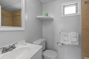 旧奥查德比奇Mt Royal Motel的白色的浴室设有卫生间和水槽。