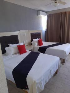 阿瓜斯卡连特斯HOTEL SiCILIA iTALIA的两张位于酒店客房的床,上面有红色枕头