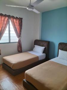 Kampong TelokKHAIRUL HOMESTAY PANGSAPURI SUTERA SEBERANG JAYA的一间卧室设有两张床和窗户。