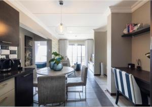 约翰内斯堡The Steynview Apartment - Fourways Sandton的厨房以及带桌椅的用餐室。