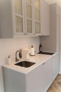 SimistiWUUD Pädaste的厨房配有白色橱柜和水槽