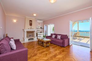 奥拉萨奇Helton SeaView Apartments的客厅配有2张紫色沙发和壁炉
