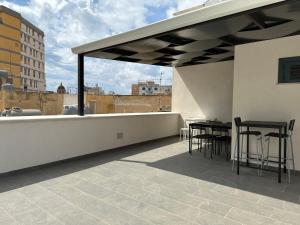 马尔萨拉La Corte 25的屋顶上带桌椅的天井