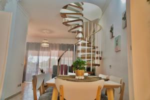 圣米格尔德阿沃纳Heart and Soul Apartment的一间带桌子和螺旋楼梯的用餐室