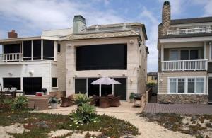 亨廷顿海滩5 Bedroom Beachfront Masterpiece的大型房屋设有带遮阳伞的庭院