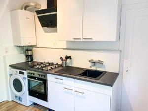 汉诺威Wohnung für 3 Gäste mit kostenlosen Parkplätzen nah am Maschsee的厨房配有白色橱柜、炉灶和水槽。