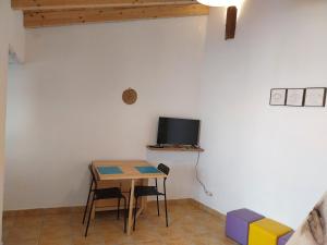 斯代塔维拉Casa Algarvia G&S的一间设有桌子的房间和墙上的电视