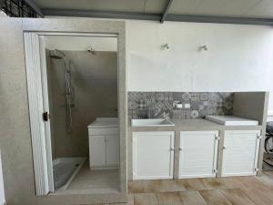 托雷圣乔万尼乌Il mare di Totino - Seaside guest house - Torre San Giovanni的浴室设有白色橱柜、淋浴和盥洗盆。