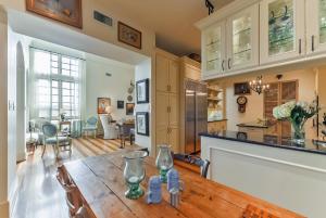 休斯顿Elegant French Patio Home with Private Pool的厨房以及带木桌的起居室。
