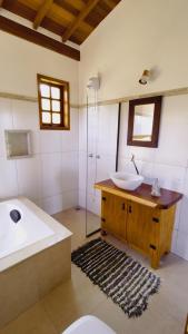 卡兰卡斯Sitio Boa Fé - 300m das cachoeiras Moinho e Salomão的浴室配有盥洗盆、卫生间和浴缸。
