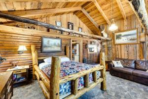 克拉马斯福尔斯Remote Escape Klamath Falls Cabin By Lake and Hikes的小木屋内一间卧室,配有一张床和一张沙发