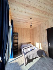 博尔若米Cottage Orcs的卧室配有一张床铺,位于带木墙的房间内