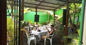 莫约加尔帕Cocos Hostel的坐在花园里桌子上的男人