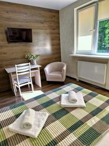 利沃夫Villa ZENKO的一间铺在地毯上的房间,配有桌子和两条毛巾