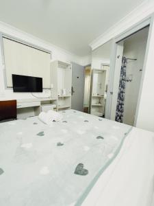 布里斯班Turbot House Hotel的一间白色卧室,配有床和电视