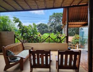 费尔南多 - 迪诺罗尼亚Casa do Maneco的庭院配有2把木椅和桌子