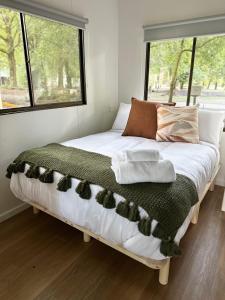 TawongaTawonga Tourist Park的一间卧室配有一张床,床上挂着猫
