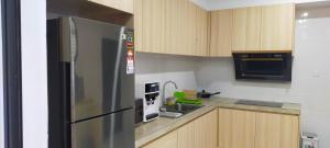 米里Sunsky Condominium Homestay的厨房配有不锈钢冰箱和微波炉。