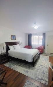 沃瓦White Fang Motel的卧室配有白色的床和红色椅子
