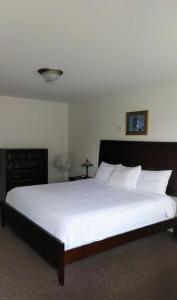 沃瓦White Fang Motel的一间卧室配有一张带白色床单的大床