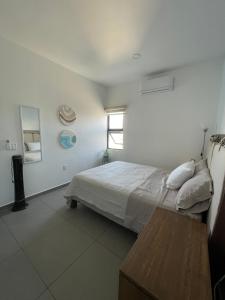 马萨特兰El Departamento Playa Sur的白色的卧室设有床和窗户