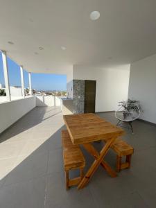 马萨特兰El Departamento Playa Sur的窗户内的木桌和长凳