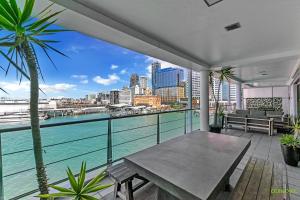 奥克兰QV Upmarket Waterfront Apartment - 787的阳台配有桌子,享有水景