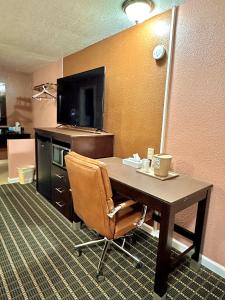Oakley安妮奥克利奥克利酒店的酒店客房配有书桌、电视和椅子