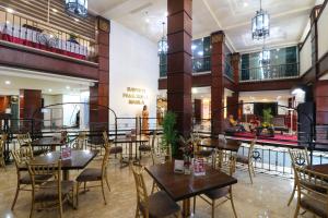 马尼拉Bayview Park Hotel Manila的大楼内带桌椅的餐厅
