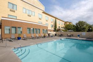 圣安吉洛圣安吉洛费尔菲尔德客栈及套房酒店的一座游泳池位于酒店前,设有椅子和一座建筑