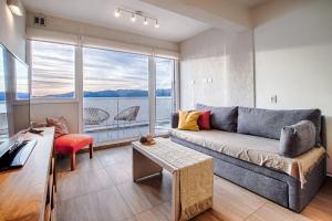 圣卡洛斯-德巴里洛切Bariloche costa del lago Ollagua的带沙发和大窗户的客厅