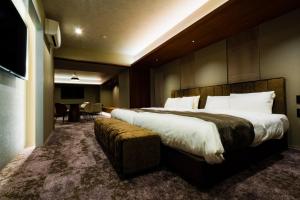 广岛Randor Hotel Hiroshima Prestige的酒店客房设有一张大床和一张桌子。