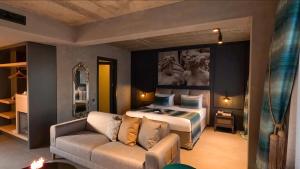 亚力卡瓦克Sandora Boutiuqe Hotel的一间卧室配有一张特大号床和一张沙发