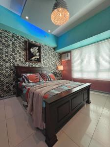 马尼拉灯塔住宅公寓的一间卧室配有一张床和一个吊灯