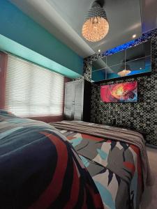 马尼拉灯塔住宅公寓的卧室配有一张床,墙上挂有绘画作品