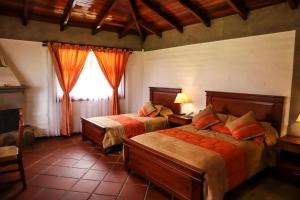 伊瓦拉Hostería San Clemente的一间卧室设有两张床和窗户。