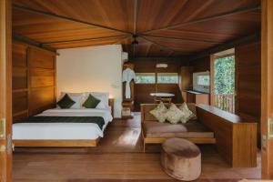 乌鲁瓦图Grün Resort Uluwatu的一间卧室配有两张床,房间设有长凳