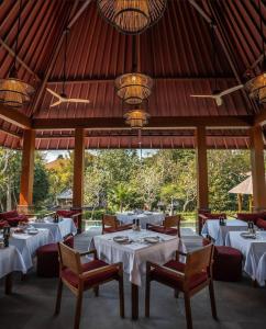 坎古La Reserve 1785 Canggu Beach的餐厅设有白色的桌椅和天花板