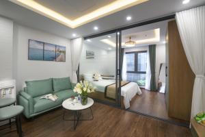 河内Bao Hung Hotel & Apartment - Tran Quoc Vuong的客厅配有绿色沙发和床。