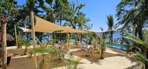 维拉港天堂湾度假酒店的一个带帐篷和椅子的庭院和一个游泳池