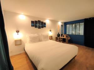维希Maison de ville, SPA Balnéo, 2 suites parentales的卧室设有一张白色大床和一扇窗户。