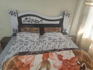 西姆拉Conifers Deluxe Room的一间卧室配有一张带黑白色棉被的床