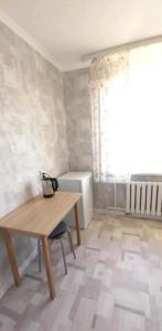 乌拉尔斯克Циолковского с кодовым замком的客房设有木桌和窗户。