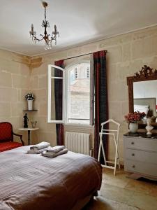 阿尔勒Appartement aux Arènes的一间卧室配有床、窗户和梳妆台