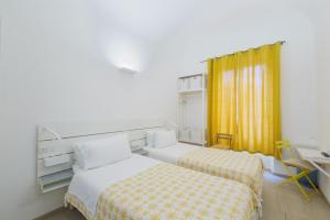 萨沃纳Central Savona B&B的酒店客房配有两张床和一张书桌