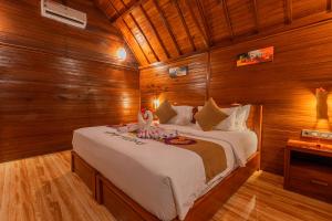 珀尼达岛Bila Penida Resort & Farm的木制客房内的一间卧室配有一张大床