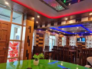 索纳马格Hotel Intermountain Sonamarg的一间设有绿色桌椅的餐厅