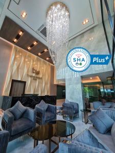 曼谷Thana Wisut Hotel - SHA Plus的大堂配有沙发、桌子和吊灯