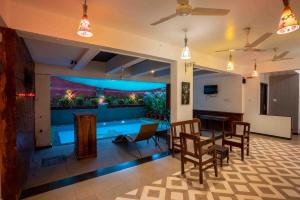 安君纳Sonnet - A boutique hotel by Lotus leaf Hotels, Anjuna, Goa的客厅设有游泳池、桌子和椅子